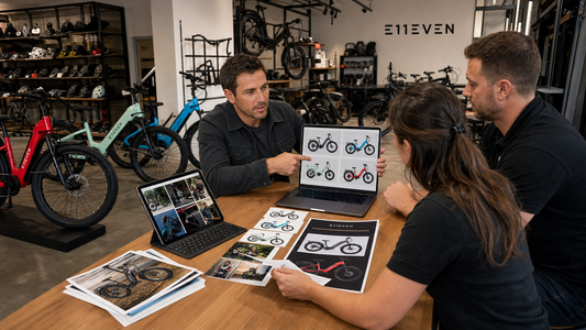 E11EVEN Electric Bikes displayed as customers compare models with a staff member in a bike showroom