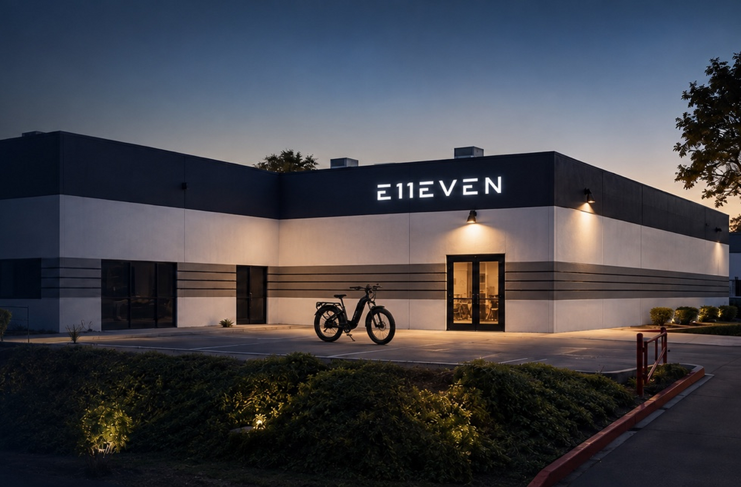 Bicycle parked outside a modern building with an illuminated sign at dusk